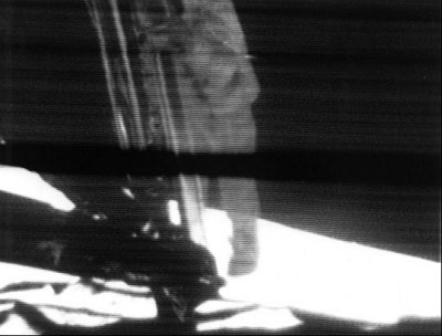 Neil Armstrong (I suppose) stepping onto the moon -- or an actor filming the moon landing conspiracy film in some secret Hollywood studio ;-) Apollo 11 -- astronaut stepping on the moon